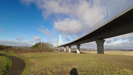 fast clouds and plane vapour trails moving across suspension bridge sunny time lapse