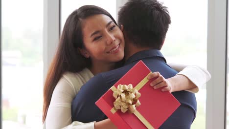 romantic couple giving gift to lover at restaurant