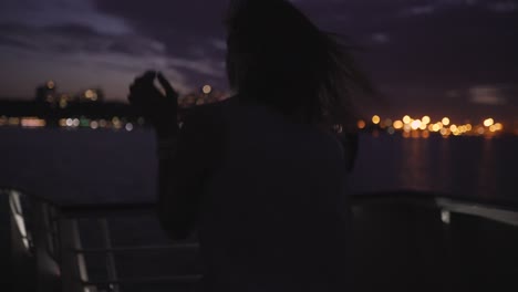 silhouette of two beautiful young women dancing on ship deck at night. girlfriends on the boat