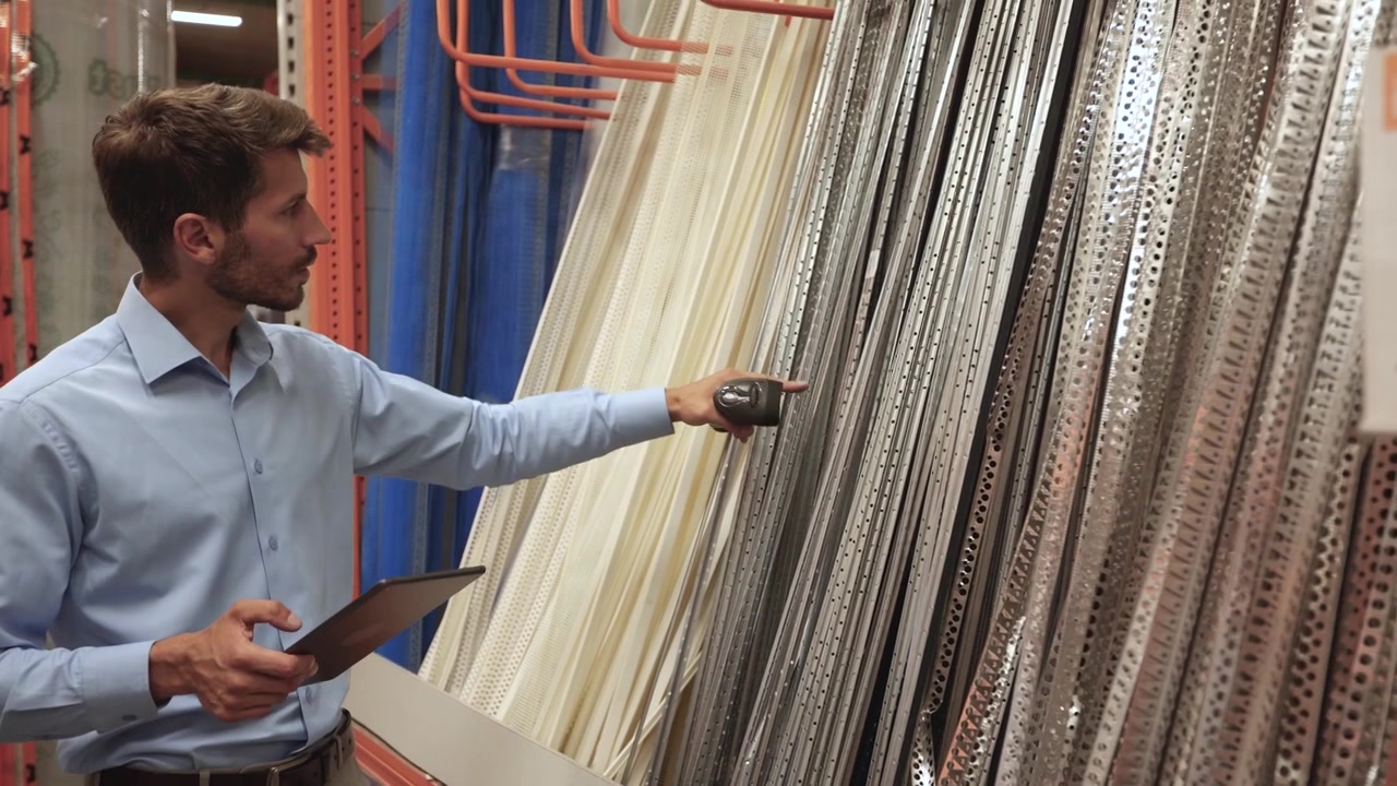 Man Scanning Products with Barcode Scanner in Warehouse