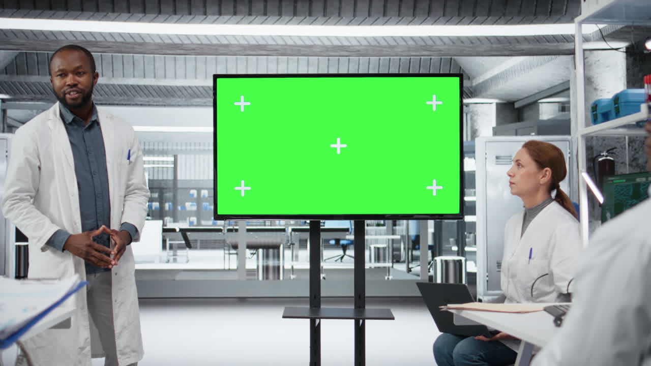 Schermo chroma key utilizzato da un professore che guida i ricercatori durante un workshop.