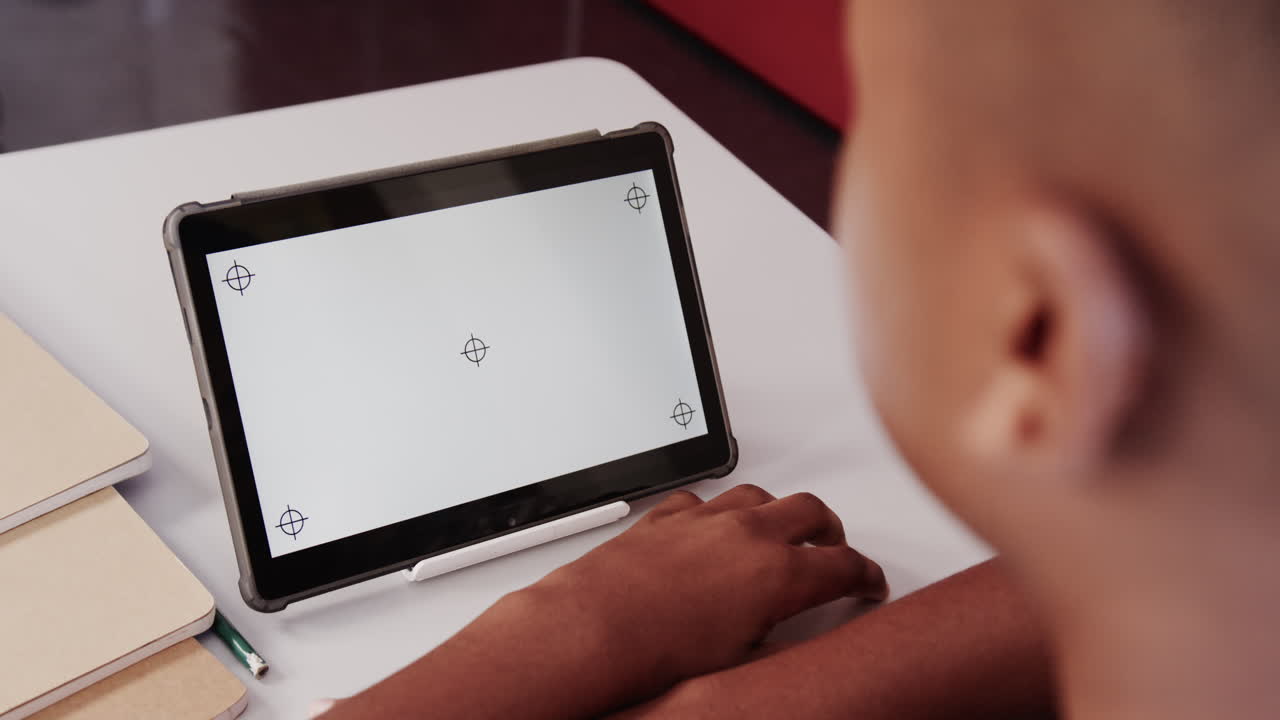 Using tablet for schoolwork, student focusing on screen in classroom, copy space