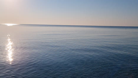 Ruhige-Wasseroberfläche-Und-Blauer-Himmel-Bei-Sonnenaufgang