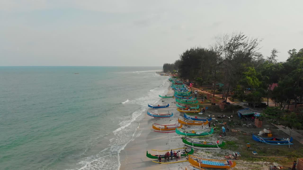 Vista aérea de barcos de pesca tradicionais alinhados ao longo da Praia de Serdang em Manggar, Belitung, Indonésia