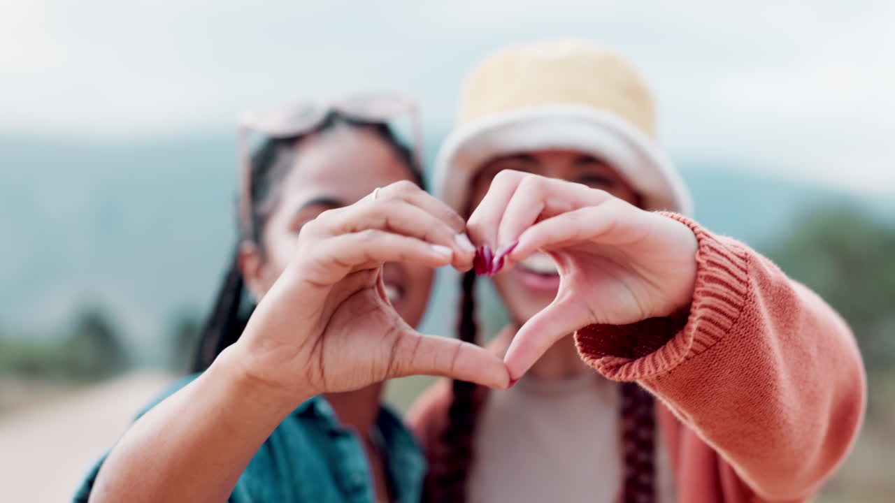 Two friends making a heart shape with their hands