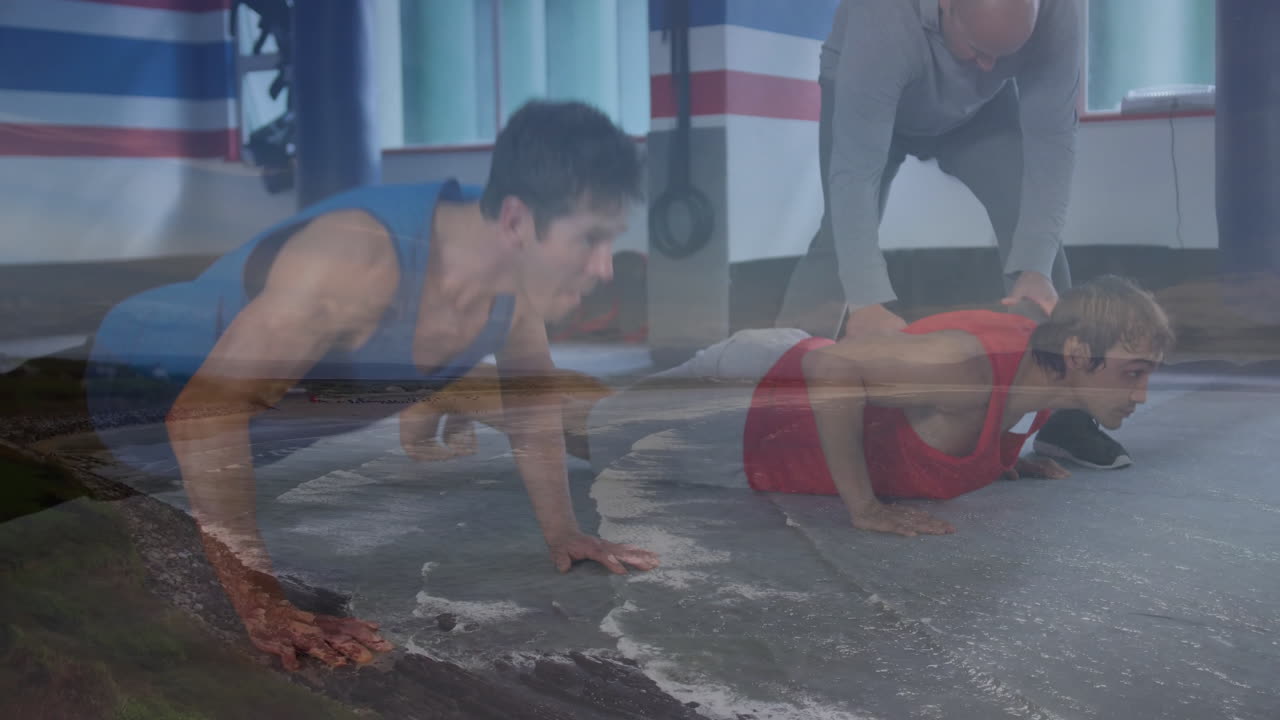 In gym, two people doing push-ups with coastal landscape animation overlay