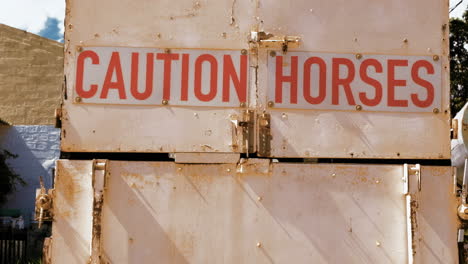 Truck-used-to-transport-horses-with-sign-saying-'caution-horses