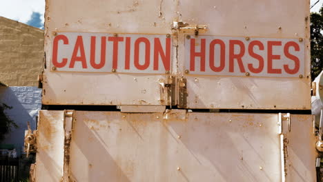 truck used to transport horses with sign saying 'caution horses