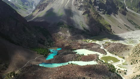 toma cinematográfica de drones que comienza en agua color turquesa y luego revela las montañas en el valle de naltar en pakistán, toma aérea