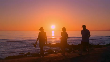 sol brillando sobre el mar con silueta de gente pasando