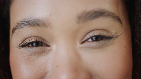 retrato de cerca de los ojos de una feliz mujer biracial sonriendo, en cámara lenta