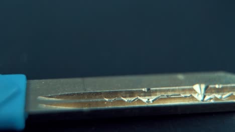 a close up macro cinematic slide shot of a metal house key, studio lighting, slow motion, 120 fps, full hd