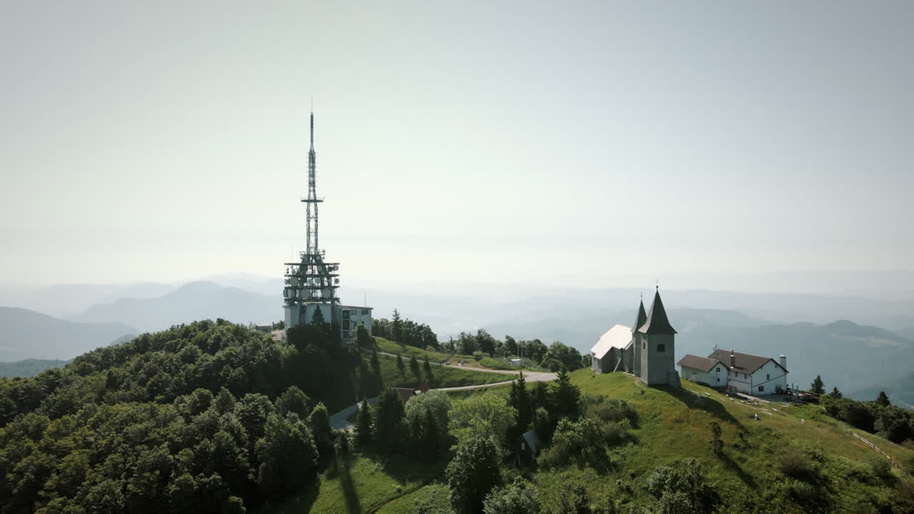 Aerial panoramic shot of dron around the hill Kum with church and tower on him in Slovenia