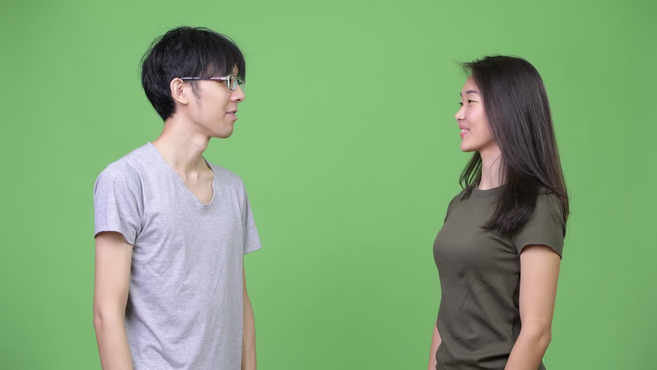 Young Asian couple giving high five