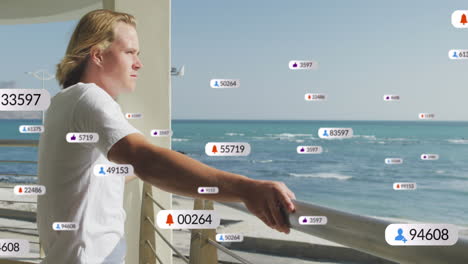 multiple digital icons with increasing numbers over caucasian man enjoying the view from balcony