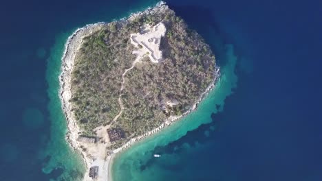 birdseye view of port palermo castle with boats docked along the coastline of the albanian riviera