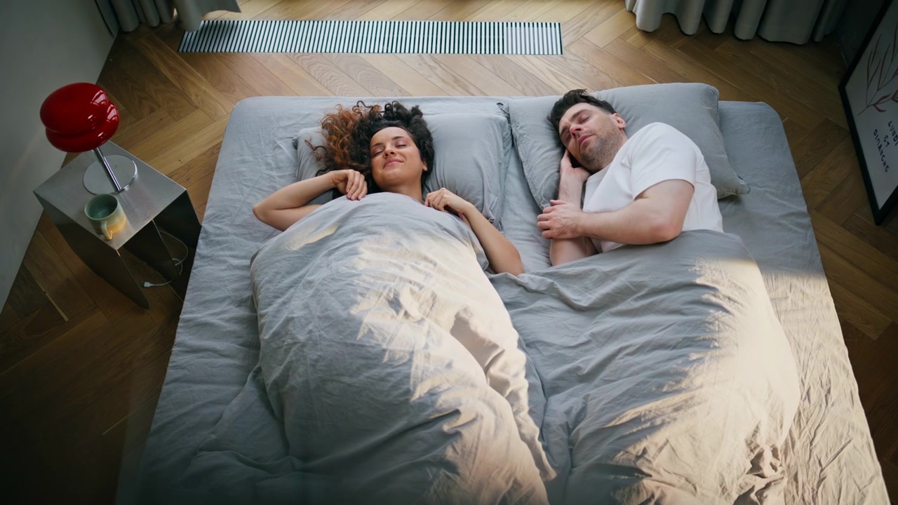 Man and woman sleeping together bed morning. Pair resting cozy bedroom top view.