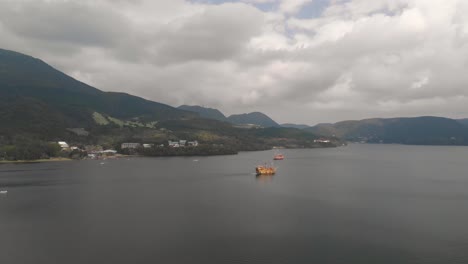 slow forward drone aerial over lake ashi in hakone with orange pirate ships passing