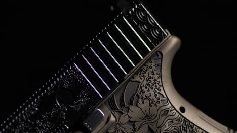 glock handgun with decorative laser engraved slide. tactical weapon. closeup, rack focus