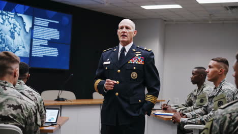 military officer briefing soldiers in a conference room