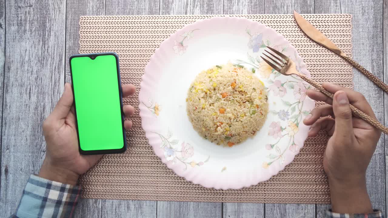 테이블 위에 스마트폰으로 긴 을 먹는 사람