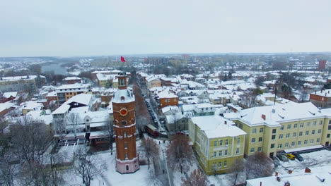 high old brick water tower in the downtown of vinnytsia, ukraine. city view on winter snowy daytime. top view.