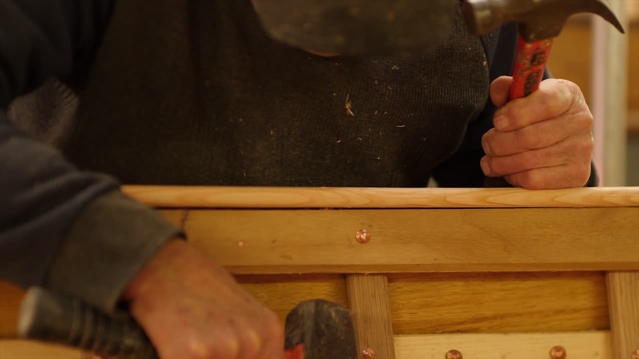 Carpenter Nailing Plank on Wooden Boat Frame