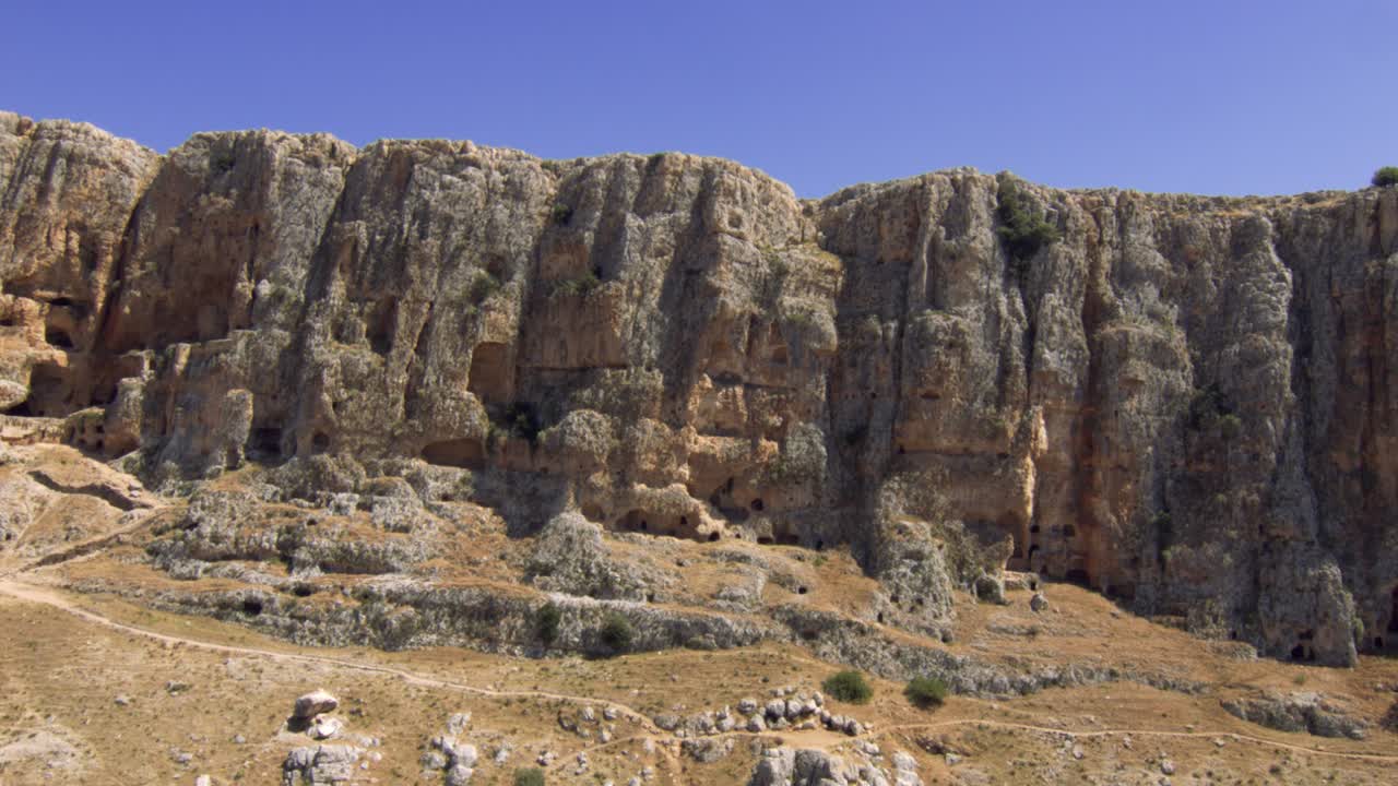 Aerial backwards flight showing mount Arbel cliff mountains during blue sky,Israel
