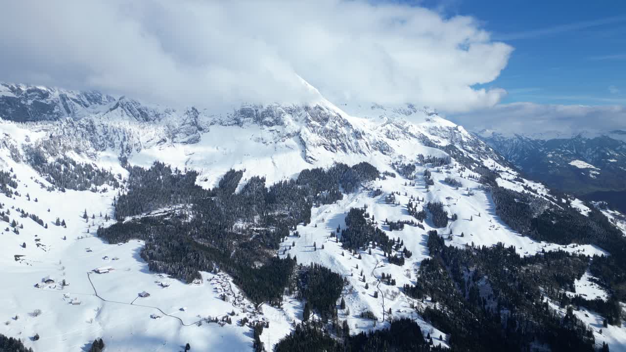 fotografía aérea en movimiento de las montañas de fronalpstock cubiertas de nieve en glarus, suiza