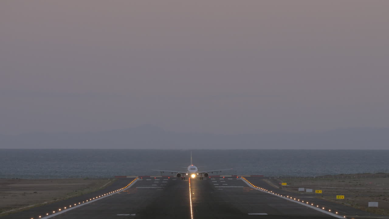 salida del avión por la noche desde el aeropuerto costero vista frontal