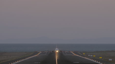 salida del avión por la noche desde el aeropuerto costero vista frontal