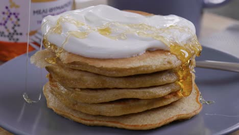 drizzling honey on a yummy stack of pancakes and yogurt