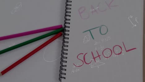 Animation-of-mathematical-equations-over-back-to-school-text-on-notebook