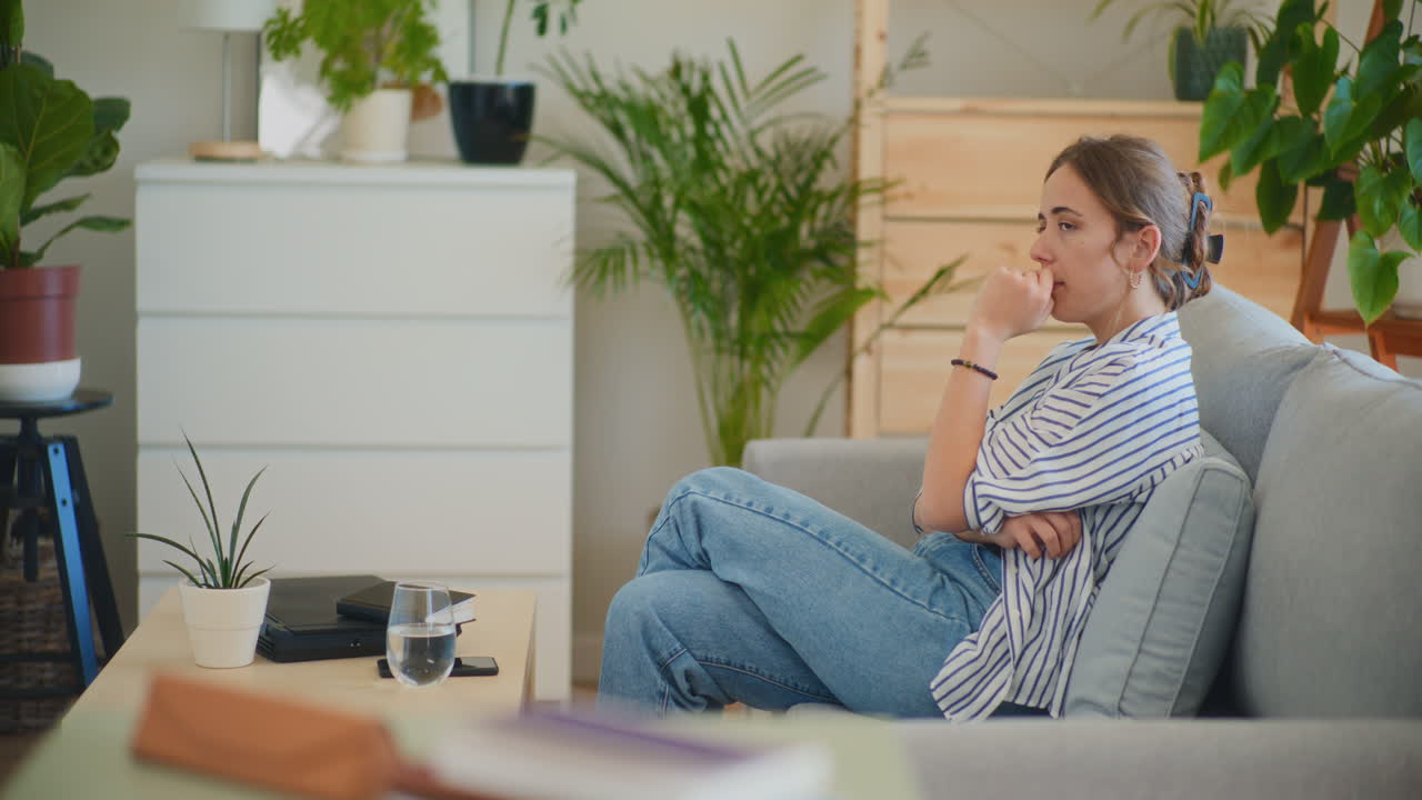 mujer desesperada escribiendo notas en el sofá