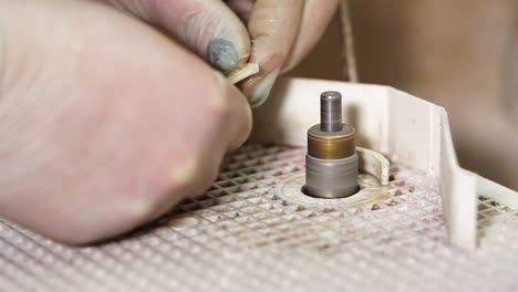 close up of a person polishing a gemstone with tools.