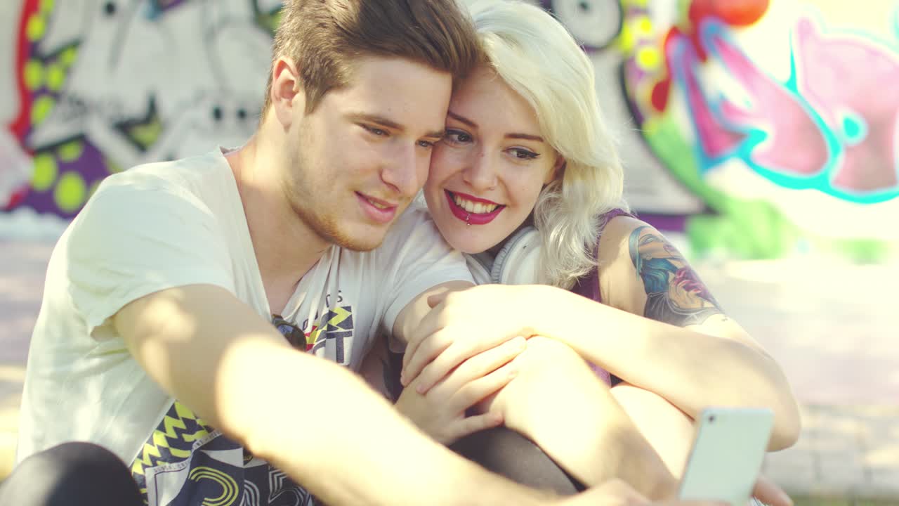 사랑하는 유행의 젊은 커플이 셀피를 찍고 있습니다.