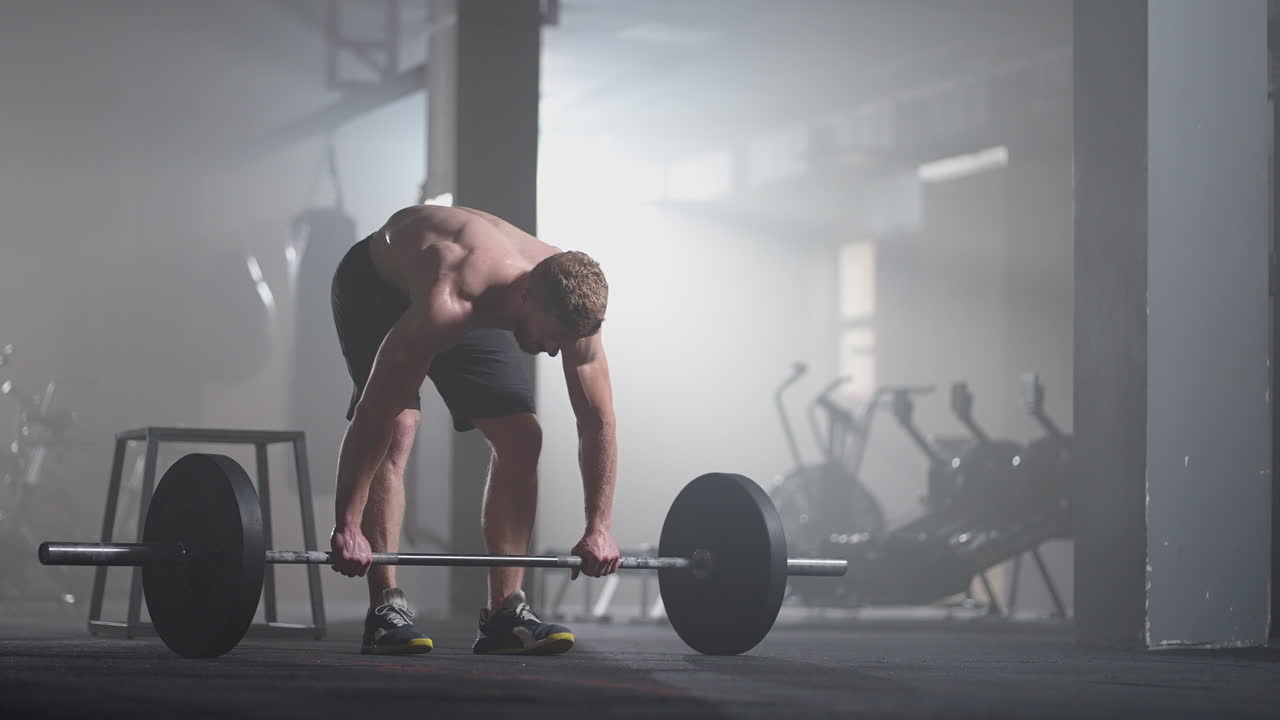 슬로우 모션: 체육관 에서 훈련 을 준비 하는 남자 파워 리프터. 비명을 지르는 남자 가 무게 를 들어 올리는 것