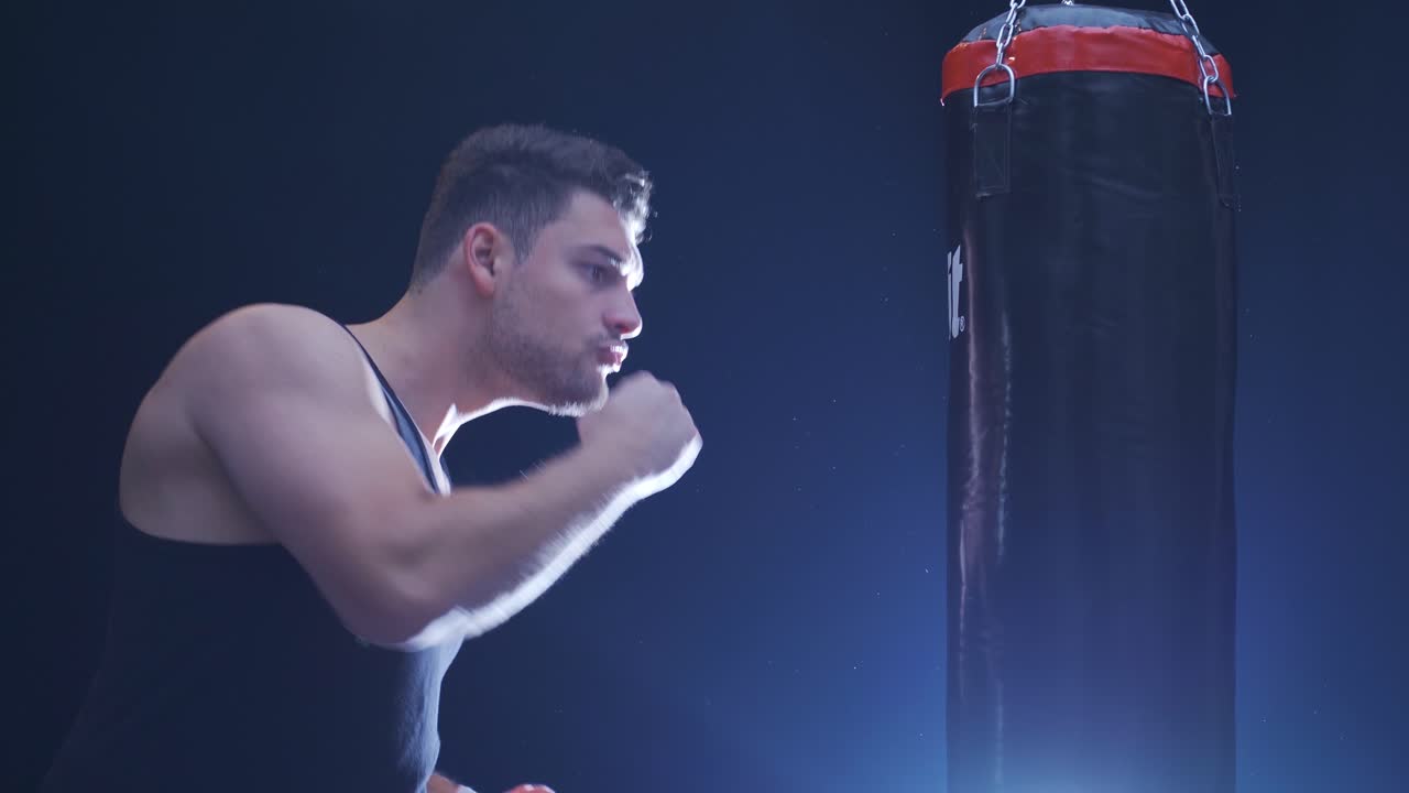 남성 권투 선수. 강한 운동 선수가 권투 가방을 때립니다.