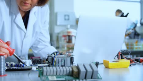 female scientist soldering circuit board 4k