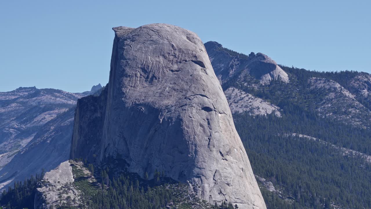 Footage featuring a slow zoom-in on the iconic Half Dome granite formation in Yosemite National Park, California