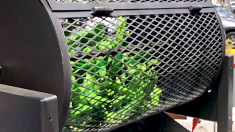 Slow-motion-tight-shot-of-jalapeño-bunch-being-roasted-outside-during-local-food-event