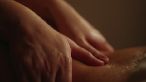 professional back massage hands in dimly lit room