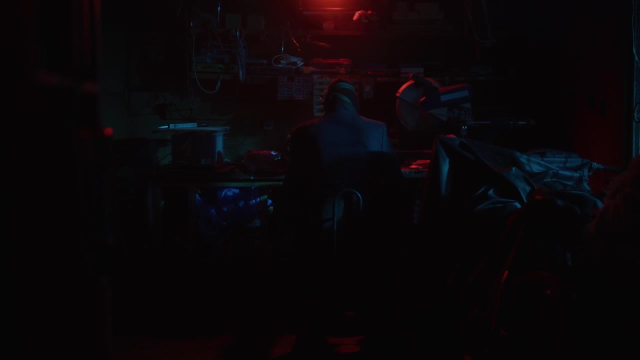 People working late at night in a dark room with red and blue lights.