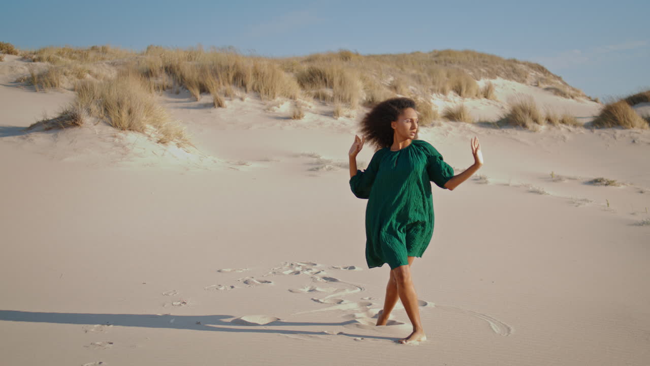 una mujer bailando sensualmente en el desierto en verano. el viento sopla sobre el bailarín.