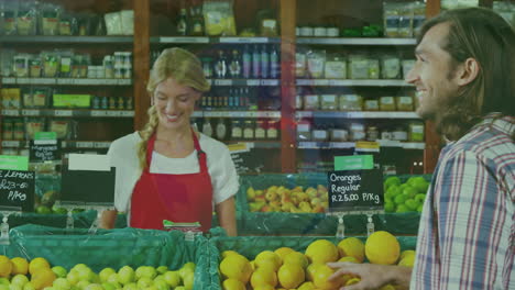 animation of financial graphs over happy caucasian female seller and male customer in grocery shop