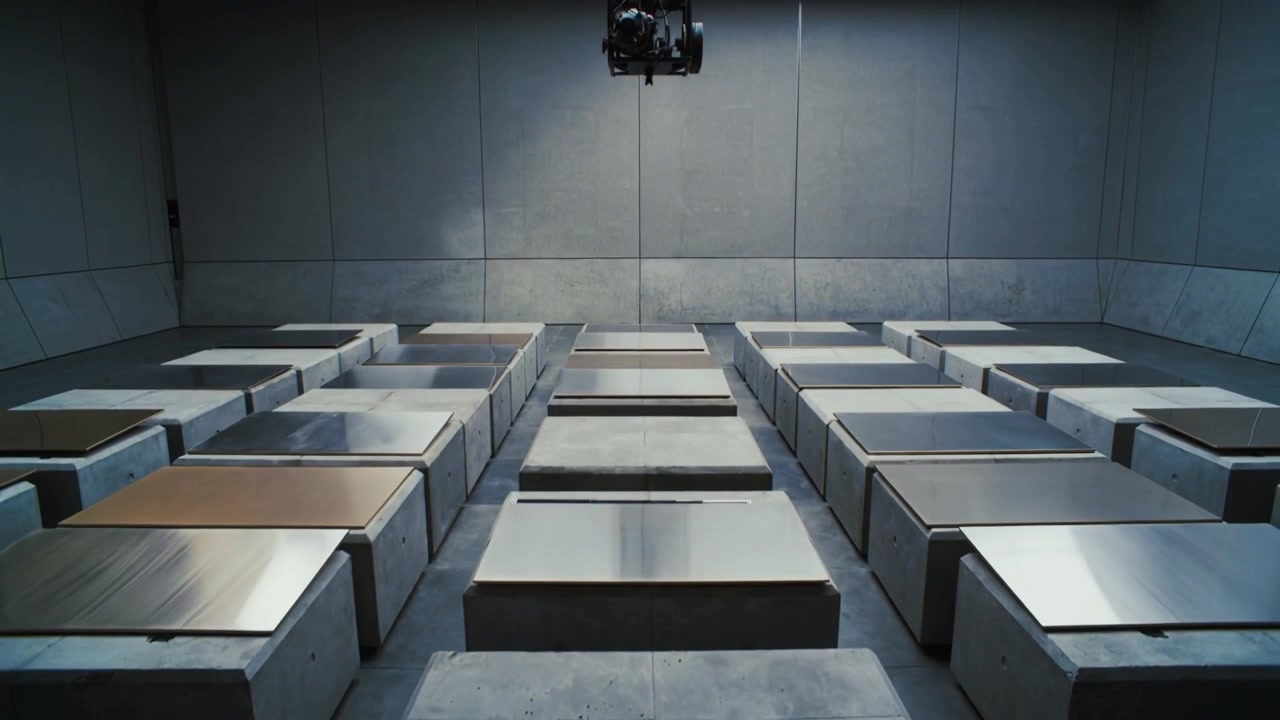 Pulling camera back revealing center concrete blocks metal-topped in test lab, showing lowering rig