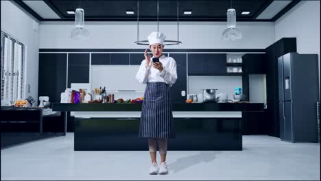 full body of asian woman chef looking at smartphone, smiling and saying wow in home kitchen