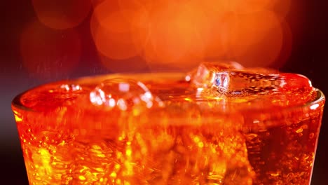 glass of soft drink. ice soft drink with splashing bubbles slow motion on a blurry light ,blurry background.