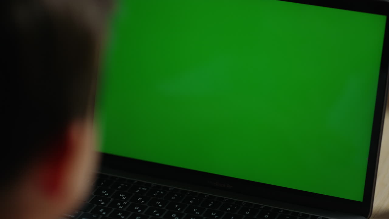 niño usando una computadora de pantalla verde. estudiante buscando una netbook de pantalla verde.