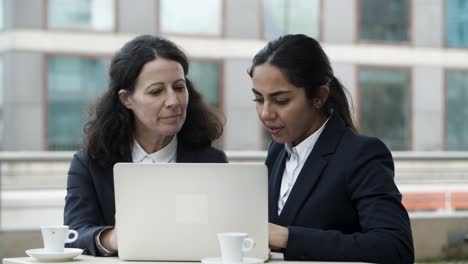 Mujeres-Empresarias-Usando-Computadora-Portátil-En-La-Cafetería.